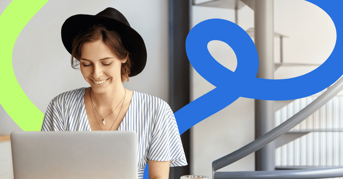 A woman wearing a black hat sat at a desk with a laptop